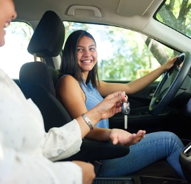 mother giving car to daughter to drive